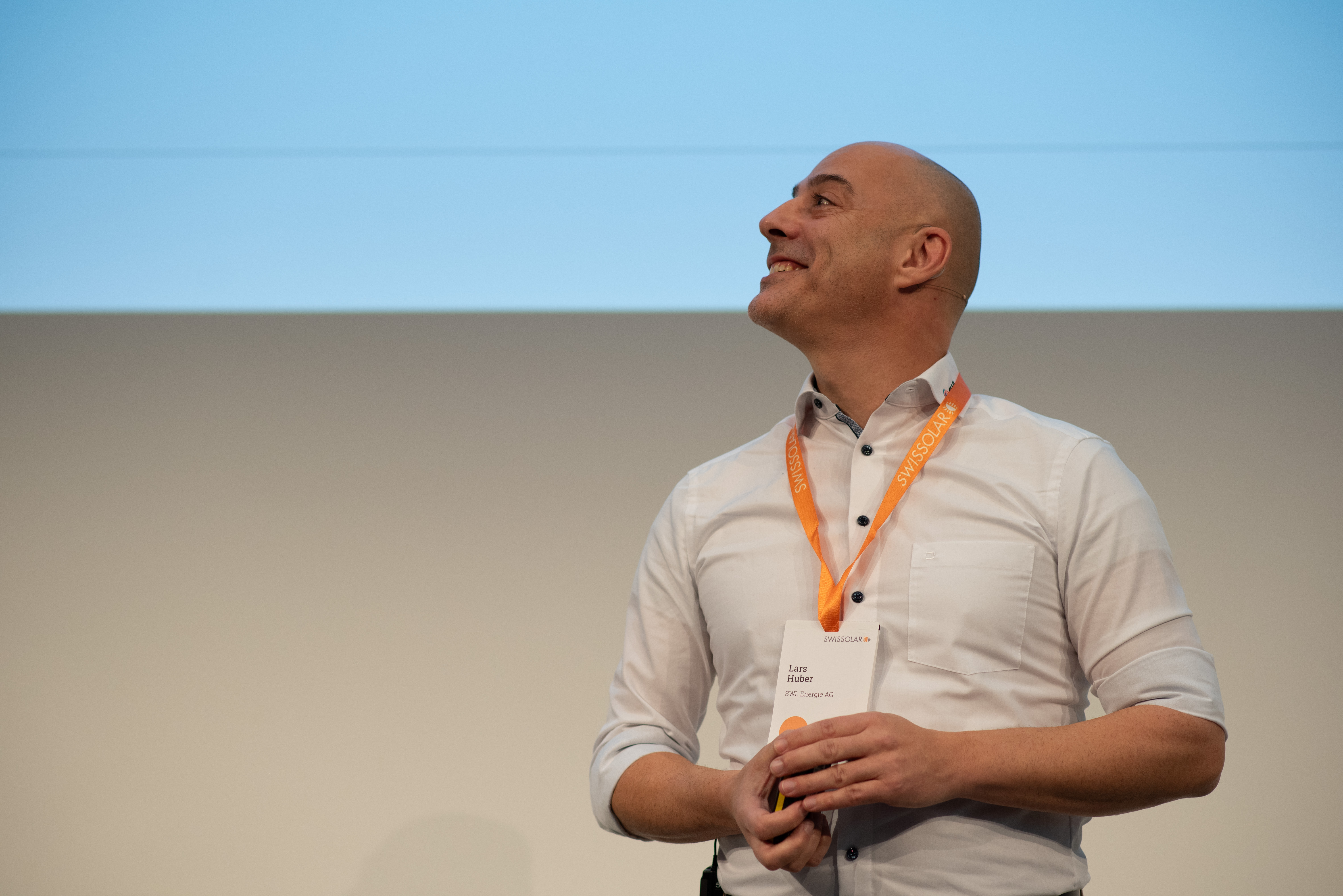 Mann mit weissen Hemd und orangenen Lenyard  | © Swissolar / Céline Farias